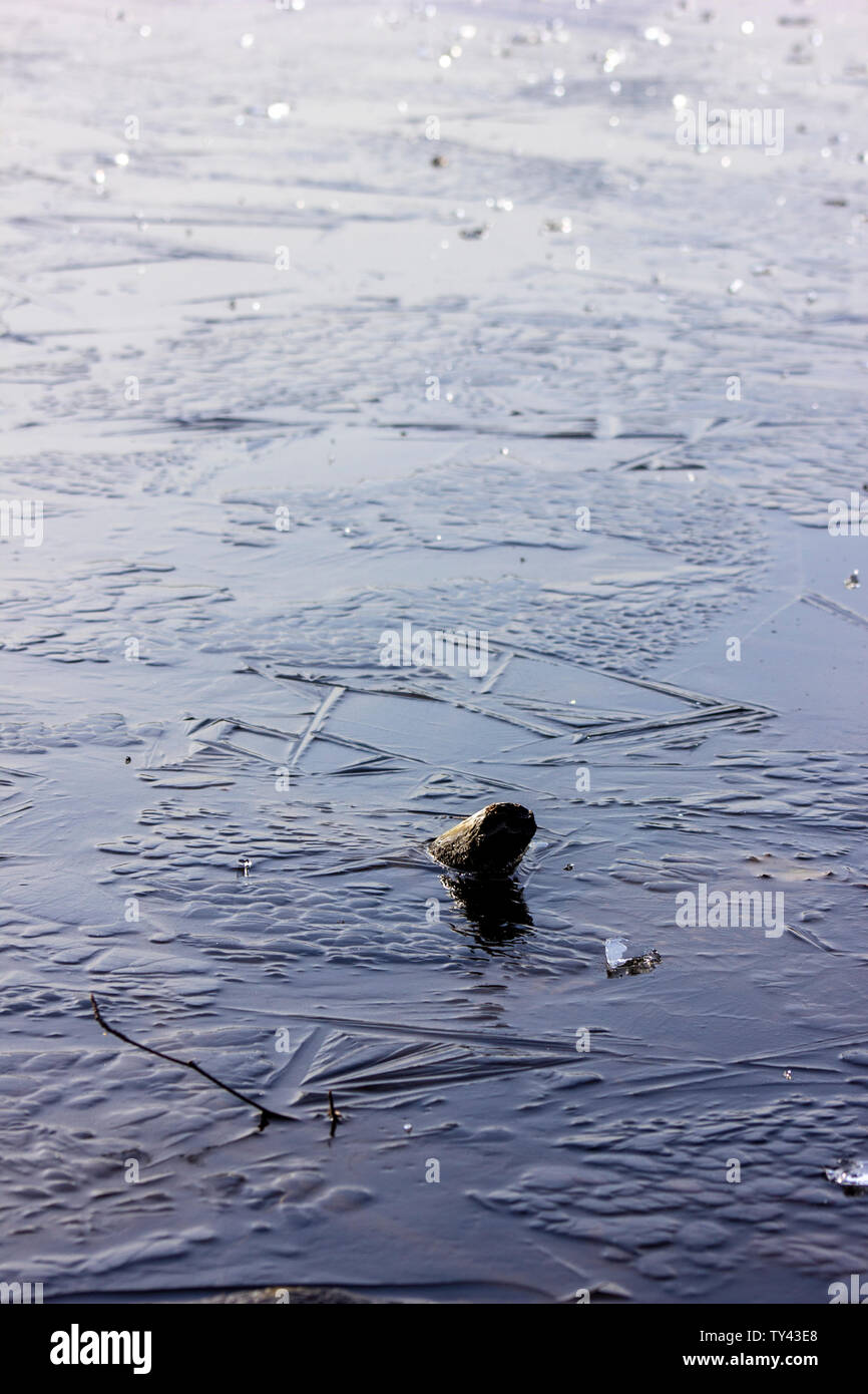 Beautiful frozen lake, covered with shattering ice.Ice cubes and broken ice on top.Bubbles under