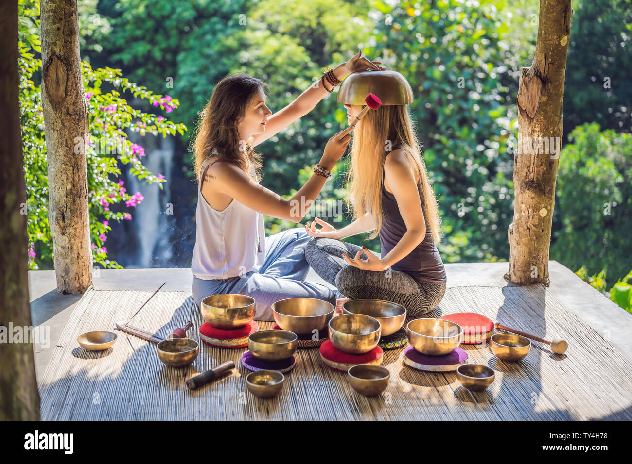 Nepal Buddha copper singing bowl at spa salon. Young beautiful woman