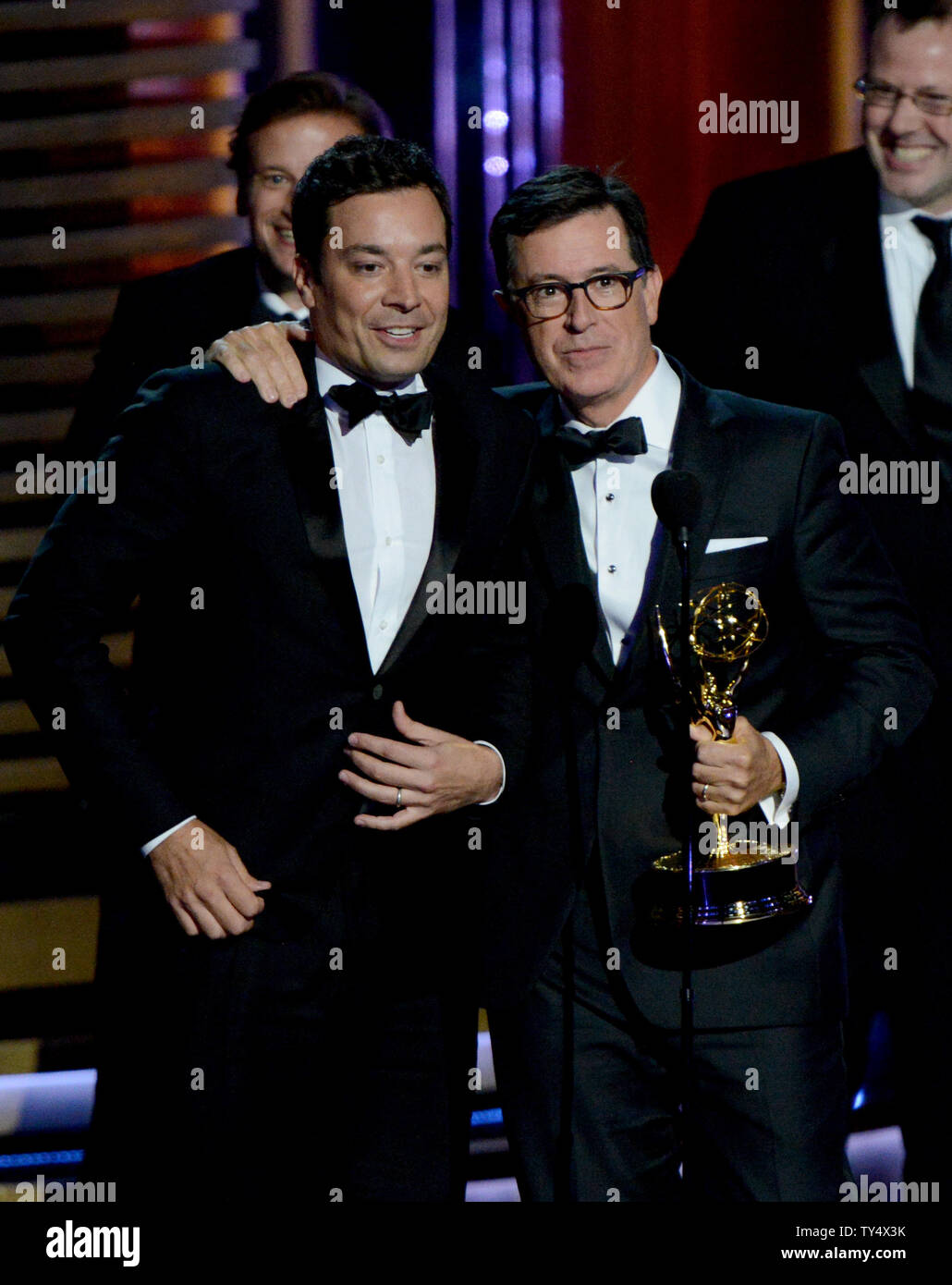 Jimmy Fallon, left, is seen onstage while Stephen Colbert and the producers of 'The Colbert Report' accept the award for outstanding variety series during the Primetime Emmy Awards at the Nokia Theatre in Los Angeles on August 25, 2014.     UPI/Pat Benic Stock Photo