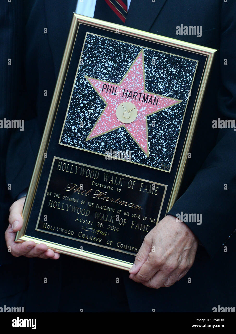 John Hartmann holds a replica plaque during a Hollywood Walk of Fame ...