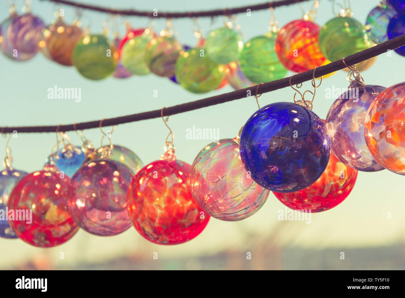 Colorful artisan made glass ornaments are one of shopping experience at the Pike Place Market overlooking Puget Sound, Seattle, USA. Stock Photo