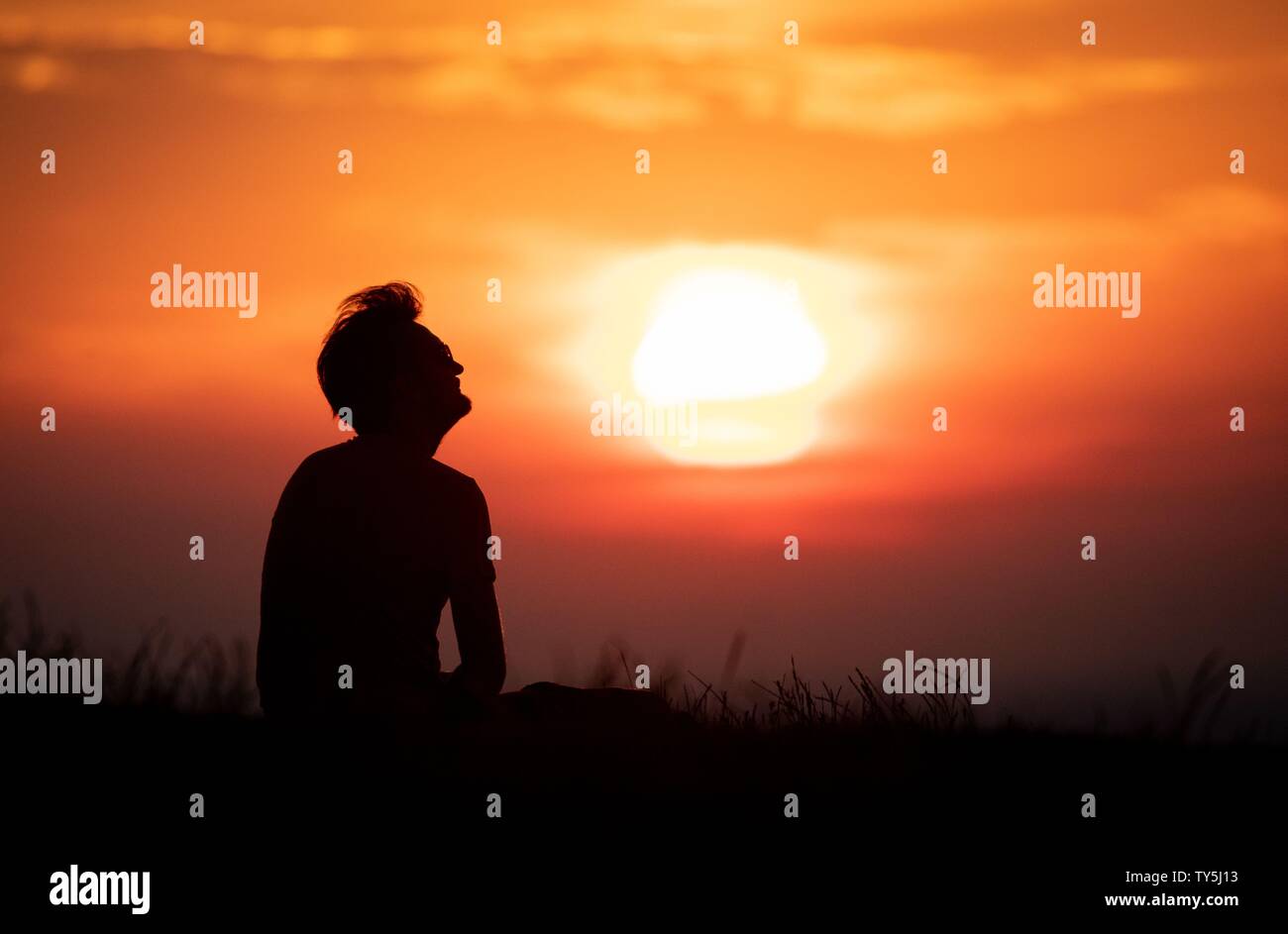 Berlin, Germany. 26th June, 2019. Fabian enjoys the sunrise on the Drachenberg over Berlin. Temperatures of up to 38 degrees are expected in the capital. Credit: Kay Nietfeld/dpa/Alamy Live News Stock Photo