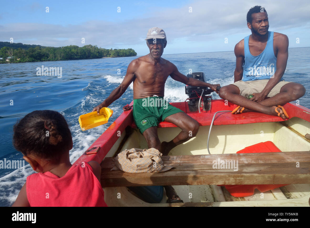 Boat driver also bailing water while crossing from Malo Island to Espiritu Santo, Vanuatu. No MR or PR Stock Photo