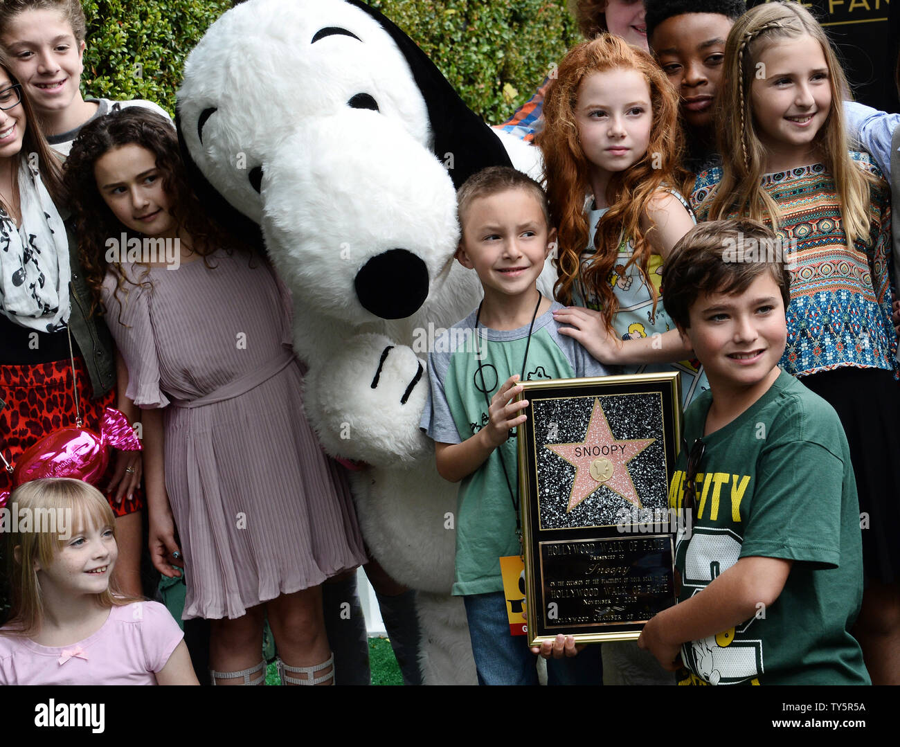"Peanuts" character Snoopy poses with voice actors during an unveiling
