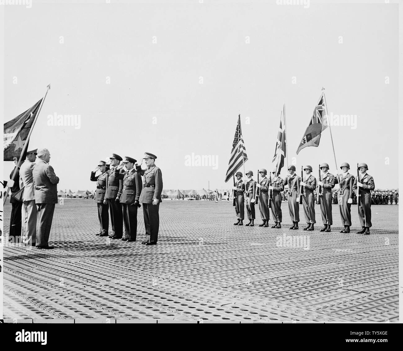 In a ceremony at the airport in Frankfort, Germany, President Harry S. Truman (third from left) presents Distinguished Service Medals to (opposite the President, L to R:) Gen. H. D. G. Crerar, Canadian Army, Air Marshall Sir Arthur Coningham, Air Marshall Sir James Robb, and Maj. Gen. Sir F. W. Guingand. President Truman is in Frankfort to inspect U. S. troops during a break in the Potsdam Conference. Stock Photo