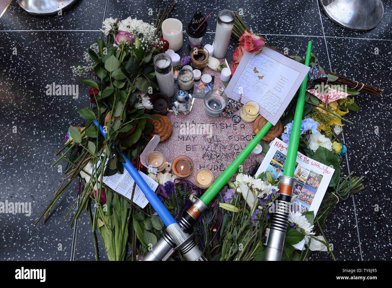 Fans gather around an impromptu Hollywood Walk of Fame Star memorial to pay tribute to 'Star Wars' actress and author Carrie Fisher, who died at age 60 Tuesday, one day before her mother, actress Debbie Reynolds died in Los Angeles on December 29, 2016.  Photo by Jim Ruymen/UPI Stock Photo