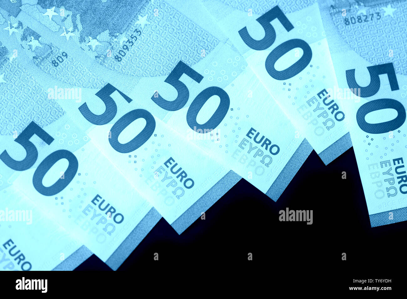 Fifty euro notes on a dark background close up. Blue color toned Stock ...