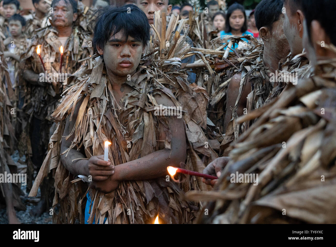 Devotees take part in the ‘Taong Putik’  or mud people festival in the town of Bibiclat,Aliaga,Nueva Ecija,Philippines.Held annually on the 24th June the century old religious festival honors the Christian Saint, John The Baptist. Before dawn those involved enter nearby rice fields adorning their bodies with mud & making cloaks made from torn banana leaves, twigs, and vines to emulate John the Baptist's appearance when he baptized Christ. Proceeding through the streets the procession is a form of penance On reaching their local Parish church a theatrical play is performed depicting the Life & Stock Photo