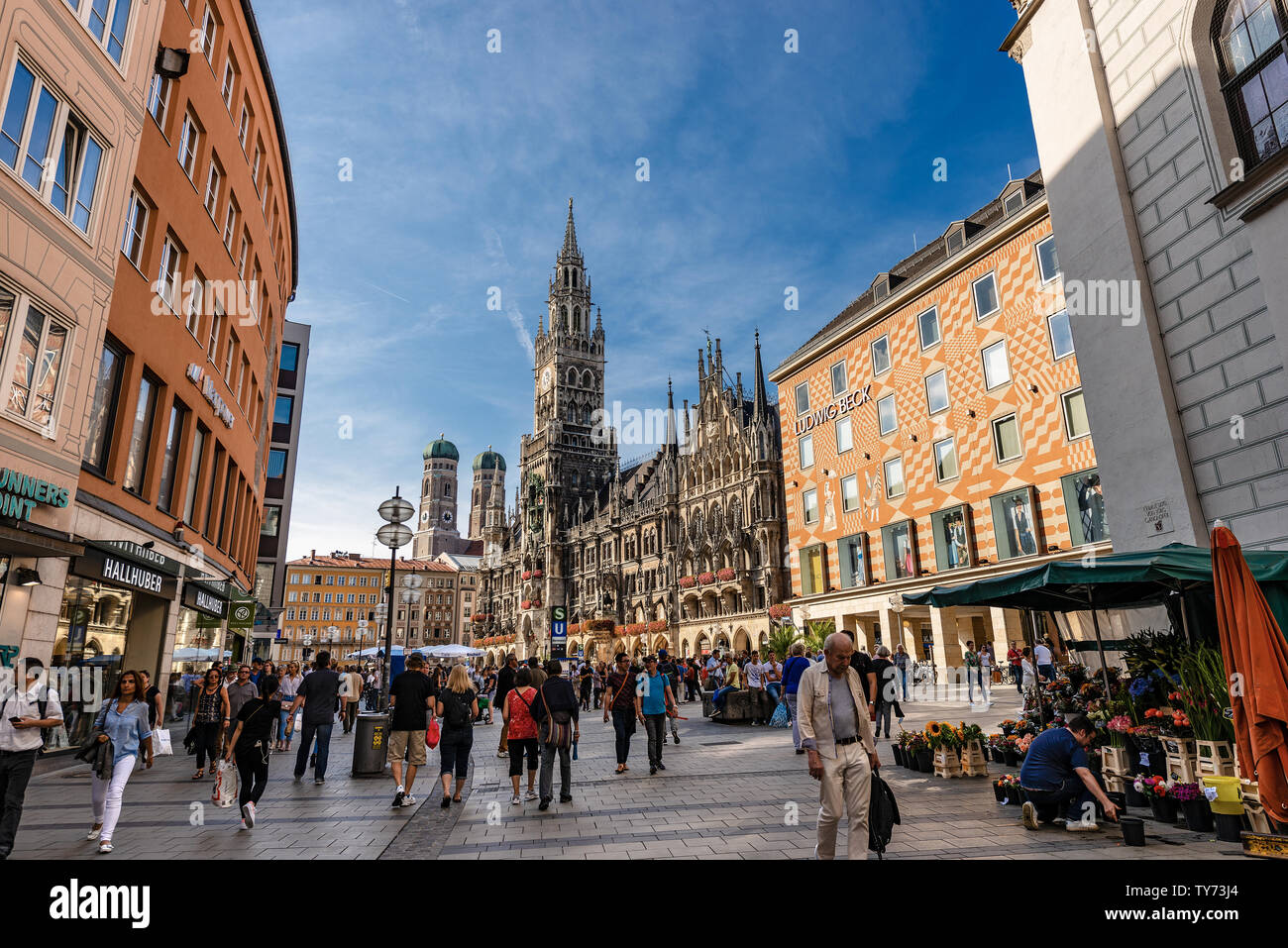 Tourists walking in Marienplatz the Town square of Munich. On background the New Town Hall (Neue Rathaus) and the Cathedral. Bavaria, Germany Stock Photo