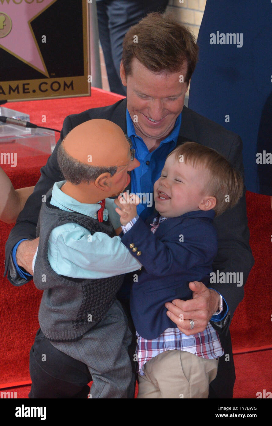 American ventriloquist and comedian Jeff Dunham looks on as his son James gets playful with