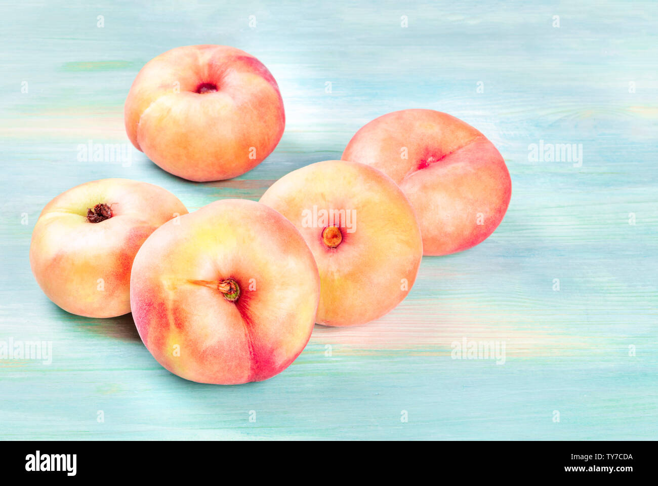 Saturn peaches on a teal background with copy space Stock Photo