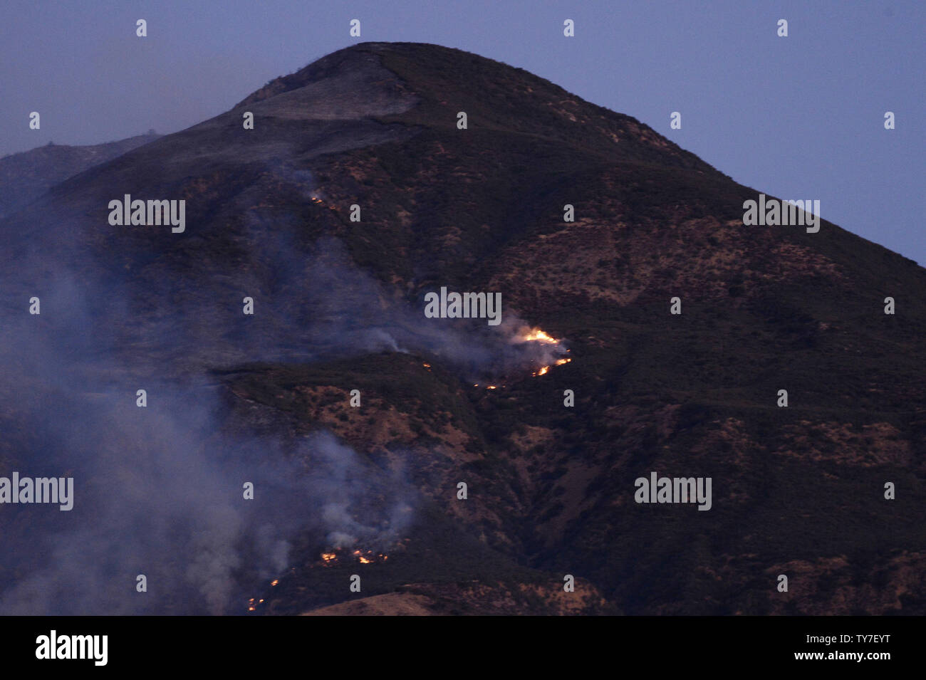 Smoke from the Thompson fire hovers during the early morning hours in Fillmore, California on