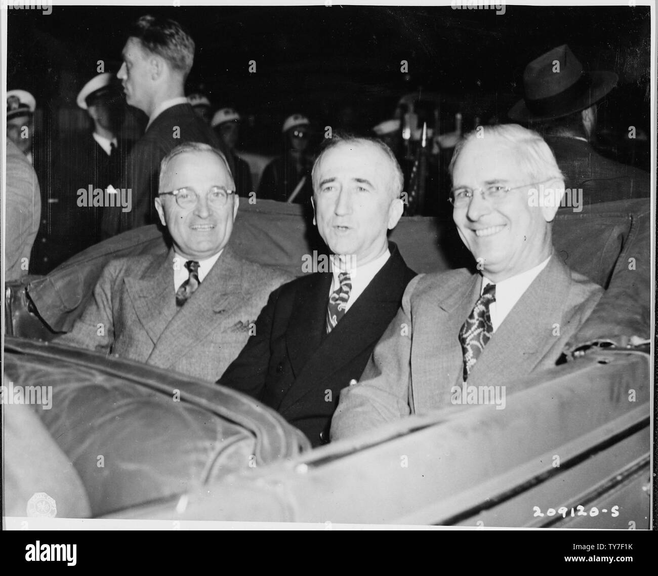 L to R: President Harry S. Truman, Secretary of State James Byrnes, and Ambassador to Belgium Charles Sawyer seated in a car as they ride from Antwerp, Belgium to Brussels. President Truman and Secretary of State Byrnes have just arrived in Antwerp en route to Germany to attend the Potsdam Conference. Stock Photo