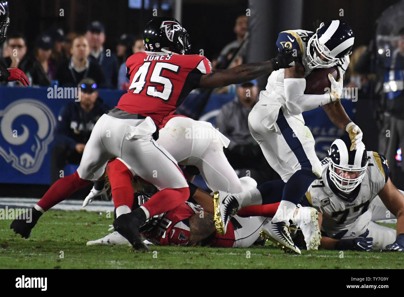 Los Angeles Rams running back Todd Gurley (R) has his face mask grabbed by  Atlanta Falcons Deion Jones (L) during their NFC Wild Card Playoff Game at  the Los Angeles Coliseum in
