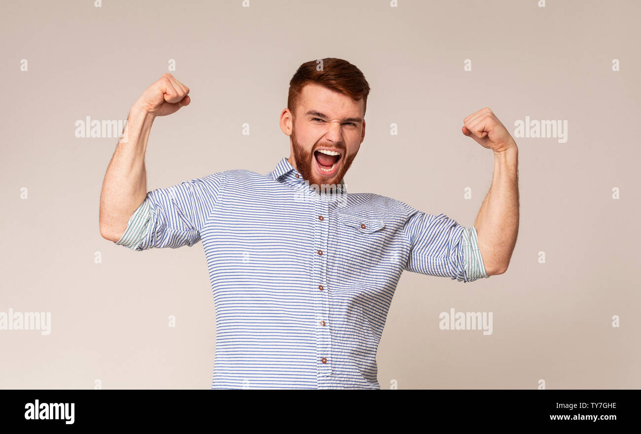 Young man showing his power in biceps on camera Stock Photo