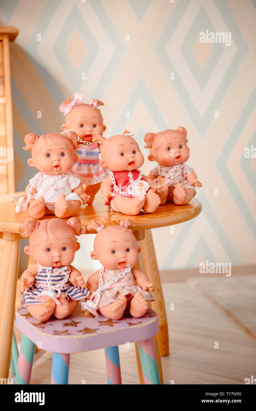 Group of cute baby dolls on the table on bright background Stock ...