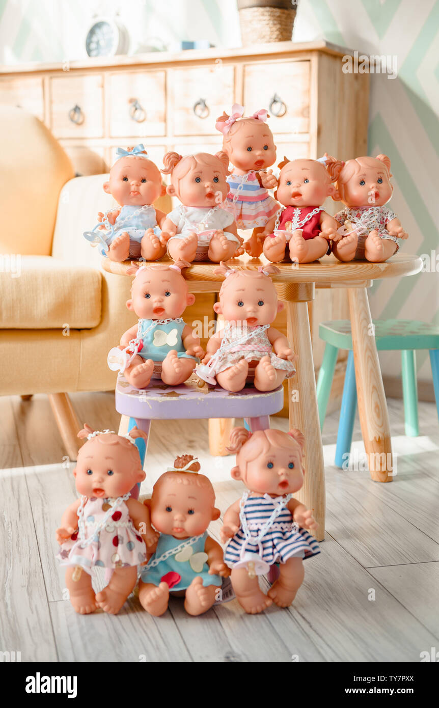 Group of cute baby dolls on the table on bright background Stock ...