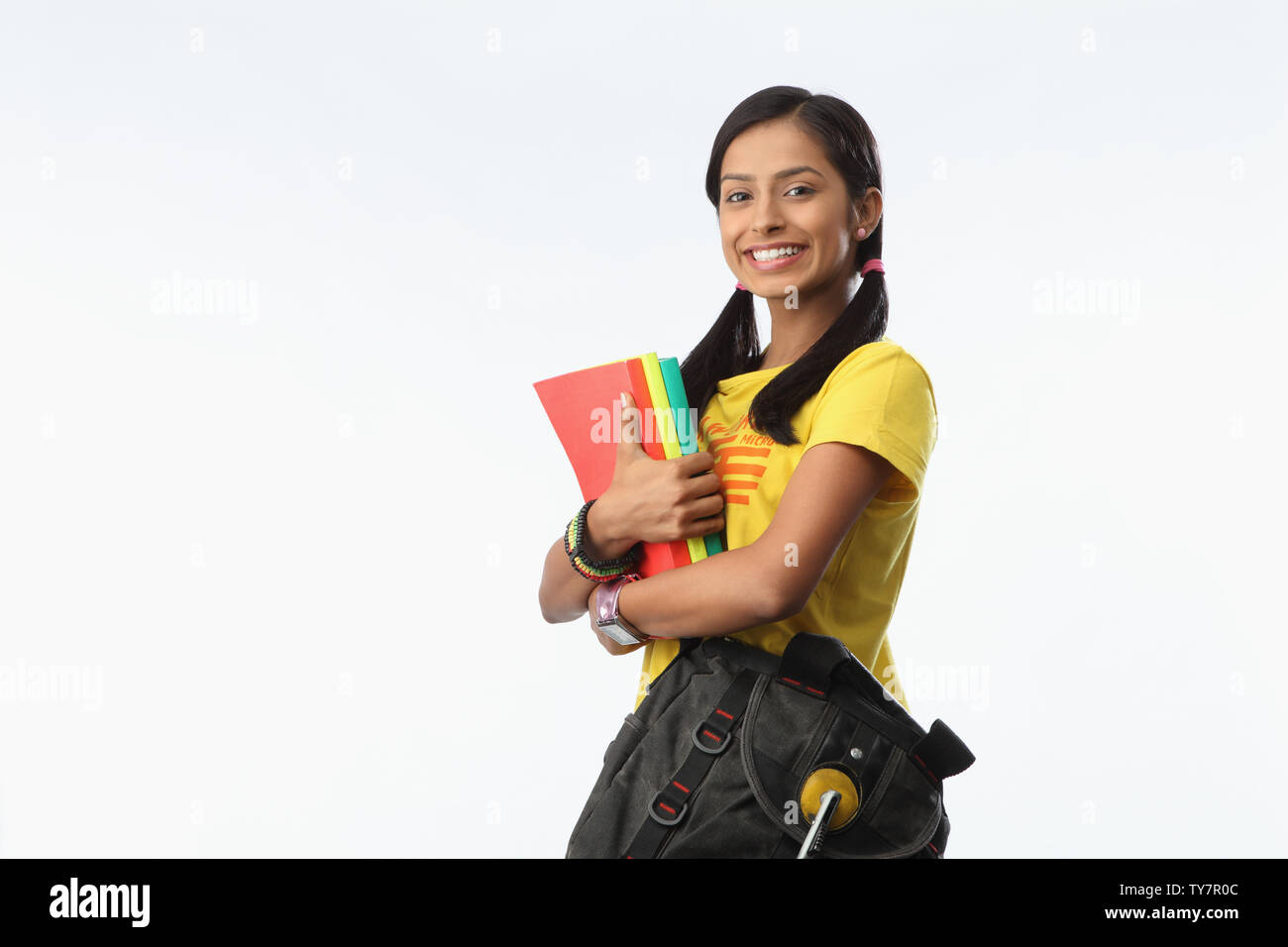 Indian college student holding books and smiling Stock Photo - Alamy