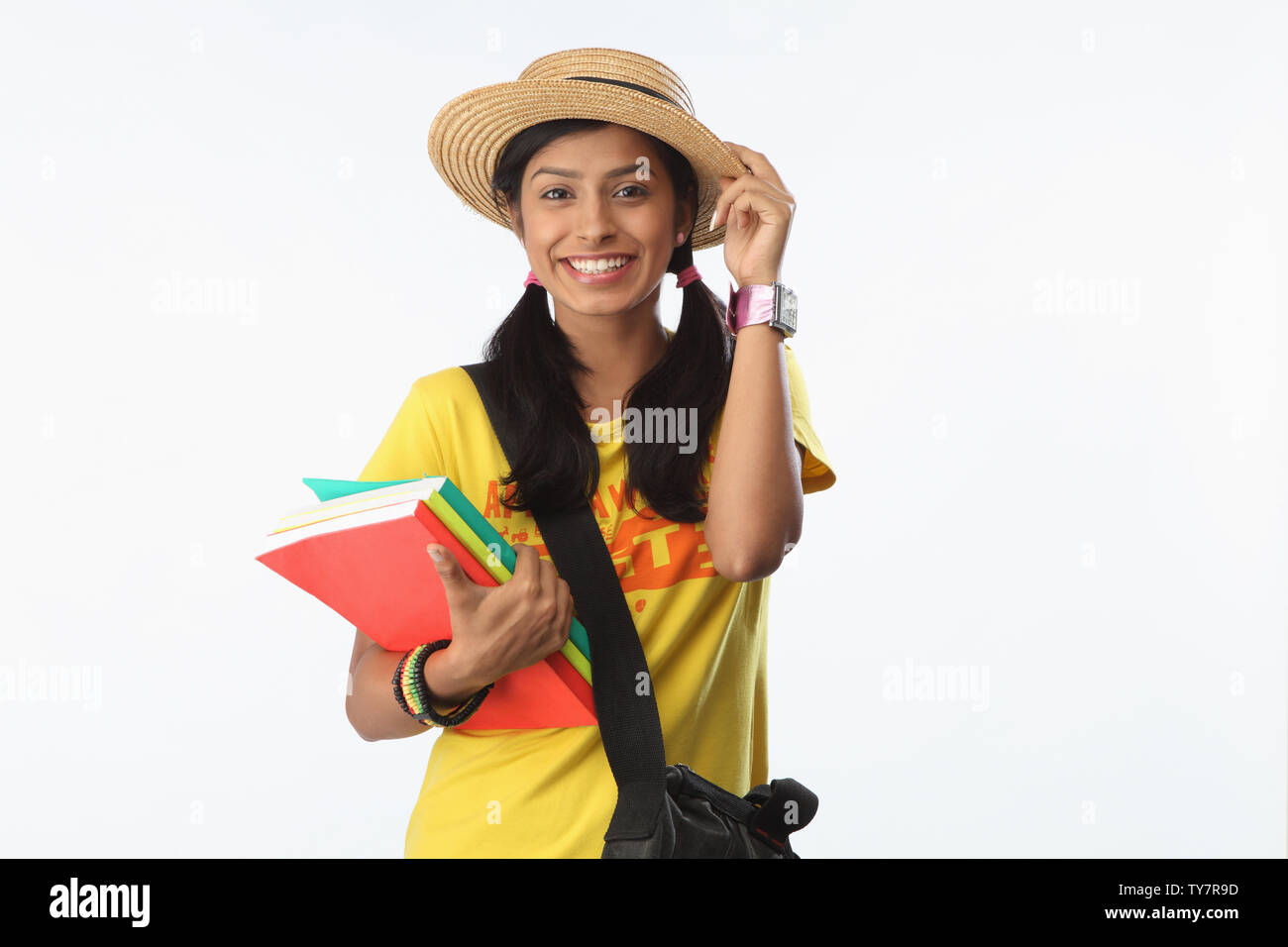 College student holding books and smiling Stock Photo - Alamy