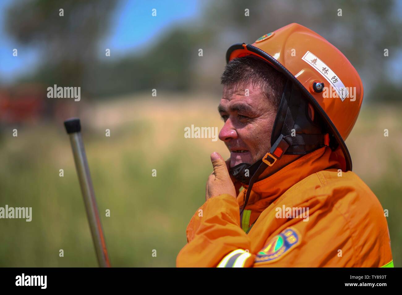 (190626) -- YULI, June 26, 2019 (Xinhua) -- A firefighter is seen after a drill at Lop Nur national wetland park in Yuli County, northwest China's Xinjiang Uygur Autonomous Region, on June 19, 2019. Heatwaves sweep the Tarim Basin every summer, and the temperature reached over 45 degrees Celsius here in this June. Situated at the border of Tarim Basin, Yuli County is exposed to the threat of forest fires. In order to prevent this risk, a batch of selected firefighters have done their firefighting work for years. They shuttle in wide expanse of desert poplars to protect the area. (Xinhua/Zhao G Stock Photo