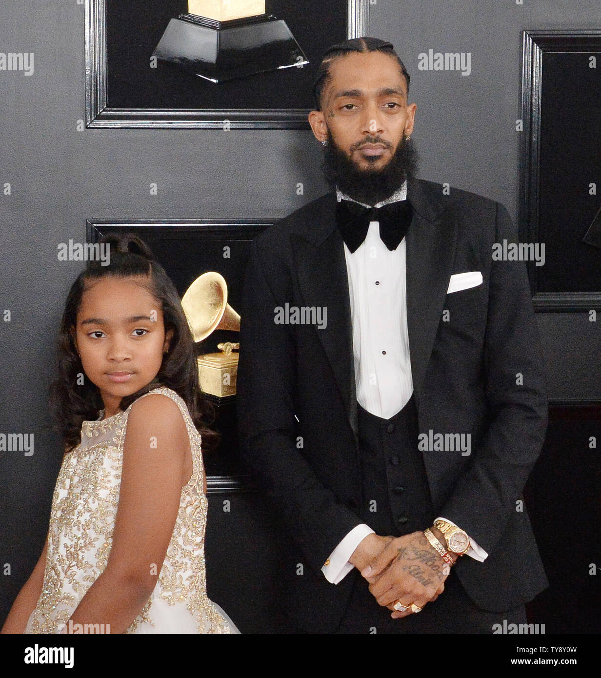 Nipsy Hussle (R) and his daughter Emani Asghedom are pictured arriving ...