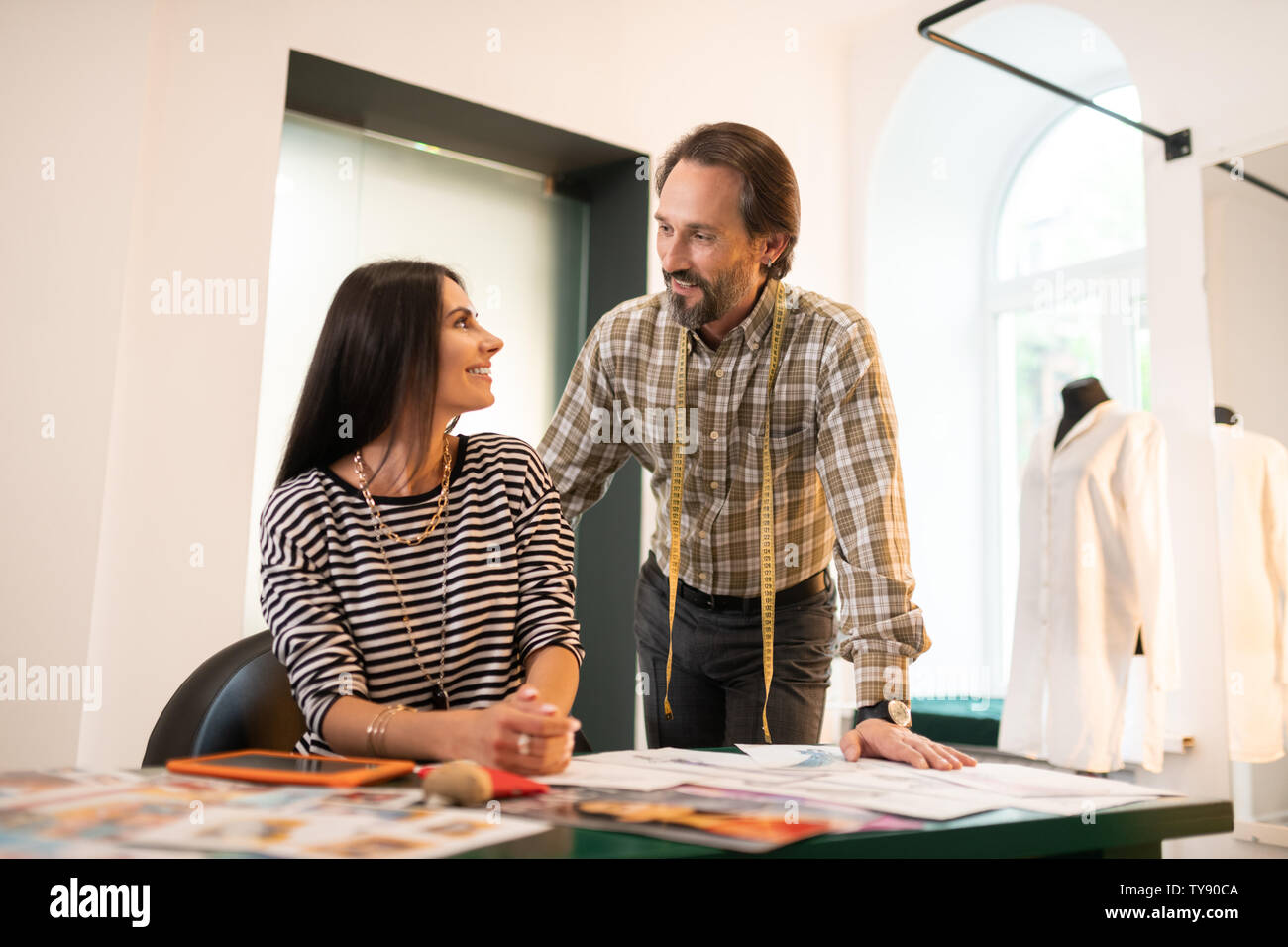 Appealing designer talking to his partner during work Stock Photo