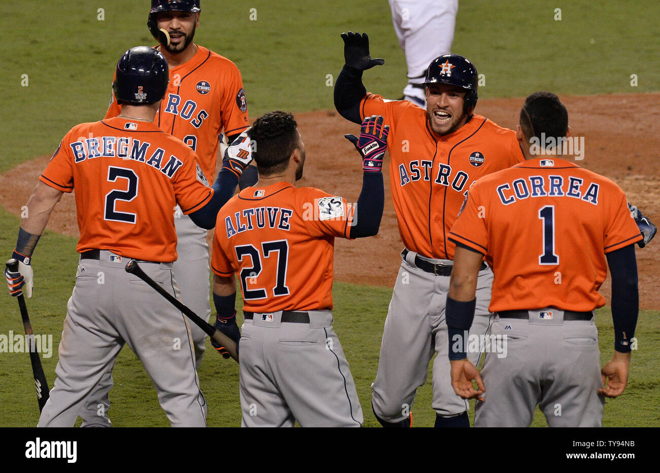 Houston Astros center fielder George Springer (4) celebrates his two-run  home run with Alex Bregman (2), Jose Altuve (27) and Carlos Correa in the  second inning against the Los Angeles Dodgers in
