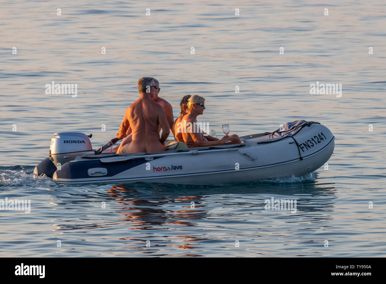 Rovinj, Croatia - June 25, 2019: Naked swinger couples drinking champagne  at sunset on a rubber dinghy in the Adriatic sea Stock Photo - Alamy