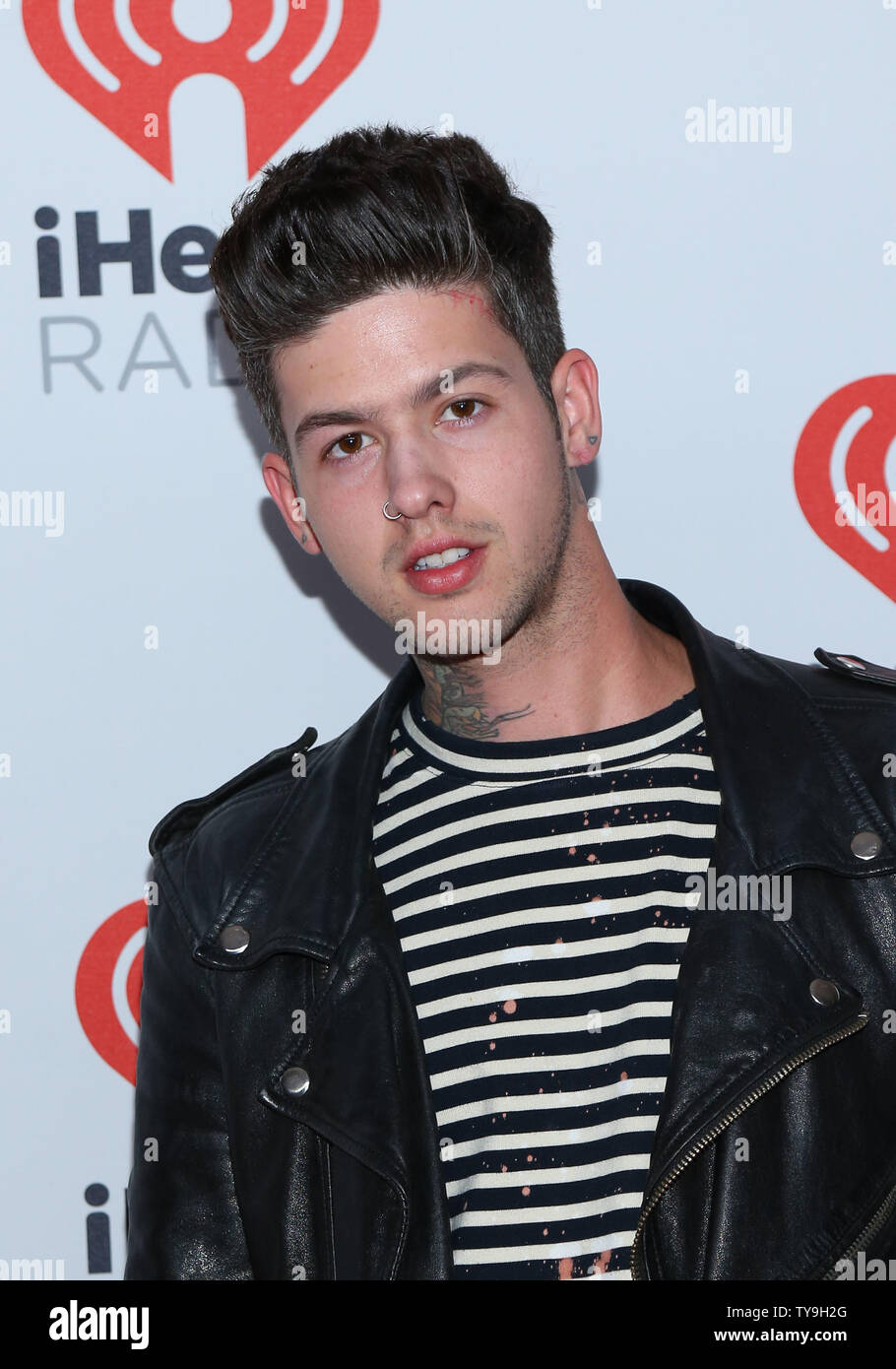 Travis Mills arrives in the press room for the iHeartRadio Music