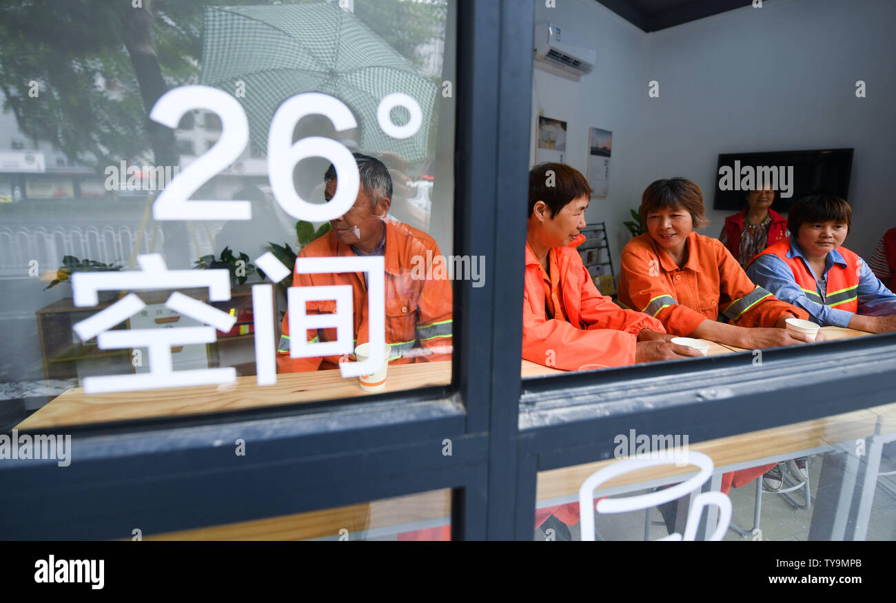 (190626) -- HUZHOU, June 26, 2019 (Xinhua) -- Outdoor workers take a rest at a public lounge in Wuxing District in Huzhou, east China's Zhejiang Province, June 26, 2019. More than 50 public lounges have been put into use in Wuxing District, where weary outdoor workers and common citizens can drink water, rest, charge their phones as well as escape the searing sun. (Xinhua/Xu Yu) Stock Photo