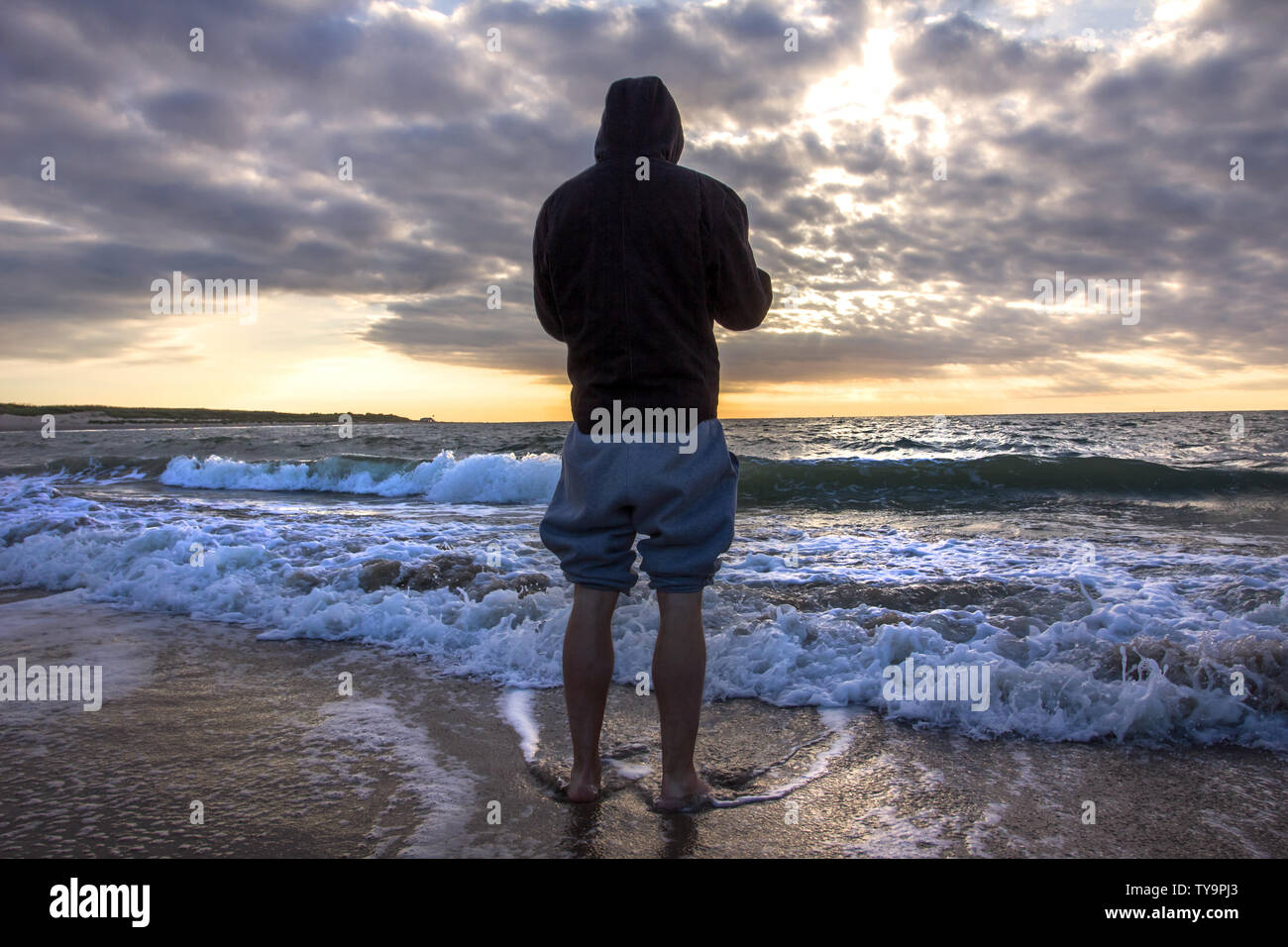 person looking at a sundown at the beach Stock Photo