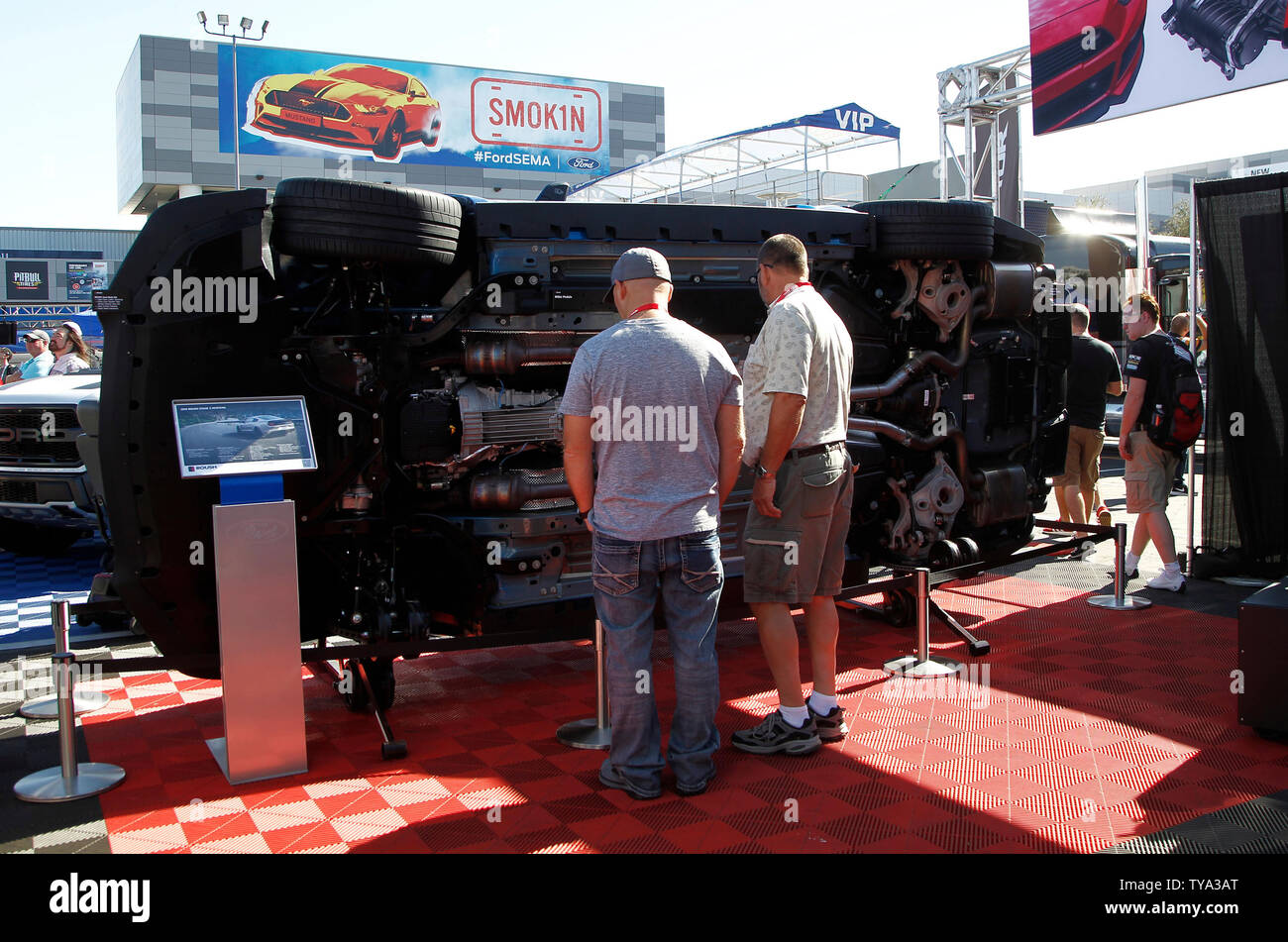 Two men view the underside of a 2019 ROUSH Stage 3 Mustang displayed on ...