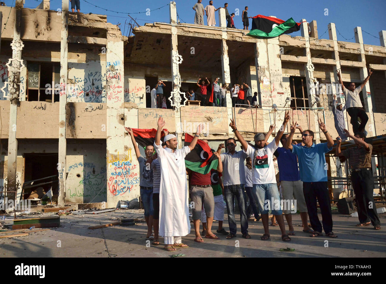 Libyan Rebels celebrate as people tour the inside of Baba al Azizia, Moammar Gaddafi's main military compound on August 26, 2011 in Tripoli, Libya. The main compound has turned into a tourist attraction and a symbol of Gaddafi's ousted regime. Numbers of Libyans are gathering to celebrate his downfall and to tour the compound which up until August 23, 2011 has been hidden from public view until the recent surge into Tripoli by rebel forces. UPI Tarek Elframawy. Stock Photo