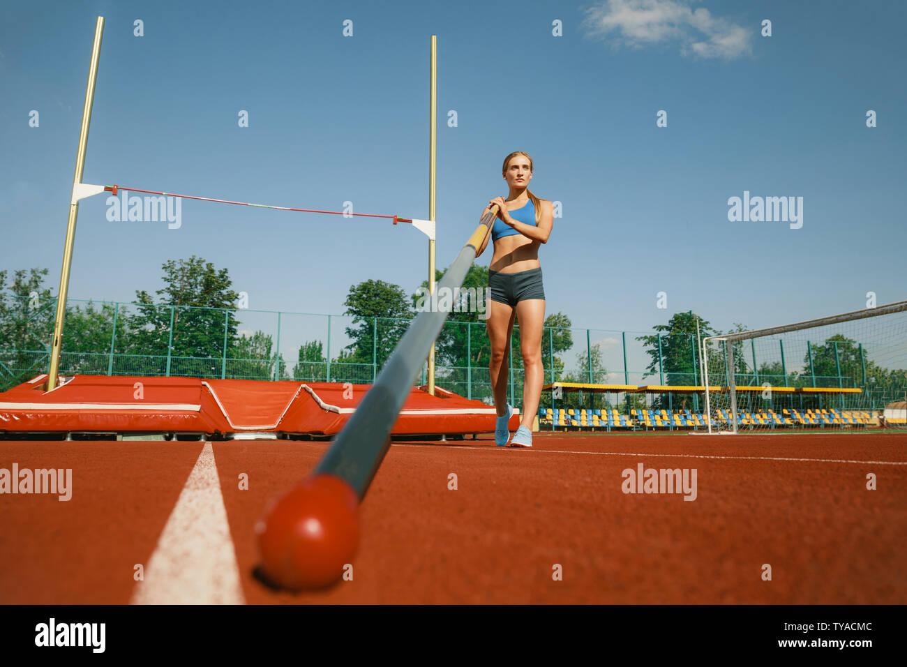 Professional female high jumper training at the stadium in sunny day ...
