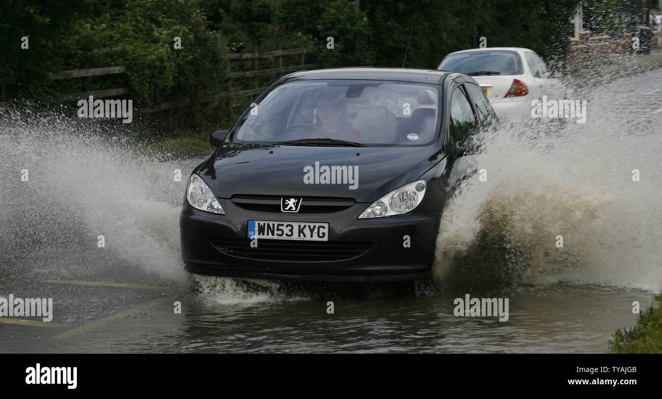 A car in the village of Tewkesbury in Gloucester drives on a flooded road after recent heavy rainfalls have flooded the area in Tewkesbury, England on July 25, 2007. Locals fear one more downpour will cause extensive flooding to the town. (UPI Photo/Hugo Philpott) Stock Photo