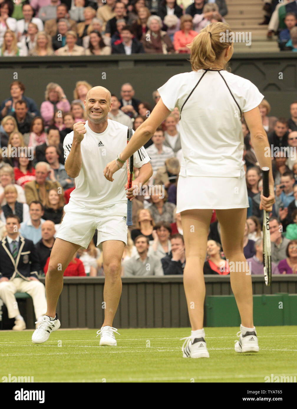 American tennis star Andre Agassi celebrates winning a point during a mixed doubles match with wife Steffi Graf against Britain Tim Henman and Kim Clijsters. The match was played to celebrate the first game on the new Wimbledon centre court with the roof fully closed on Sunday May 17 2009. (UPi Photo/Hugo Philpott) Stock Photo