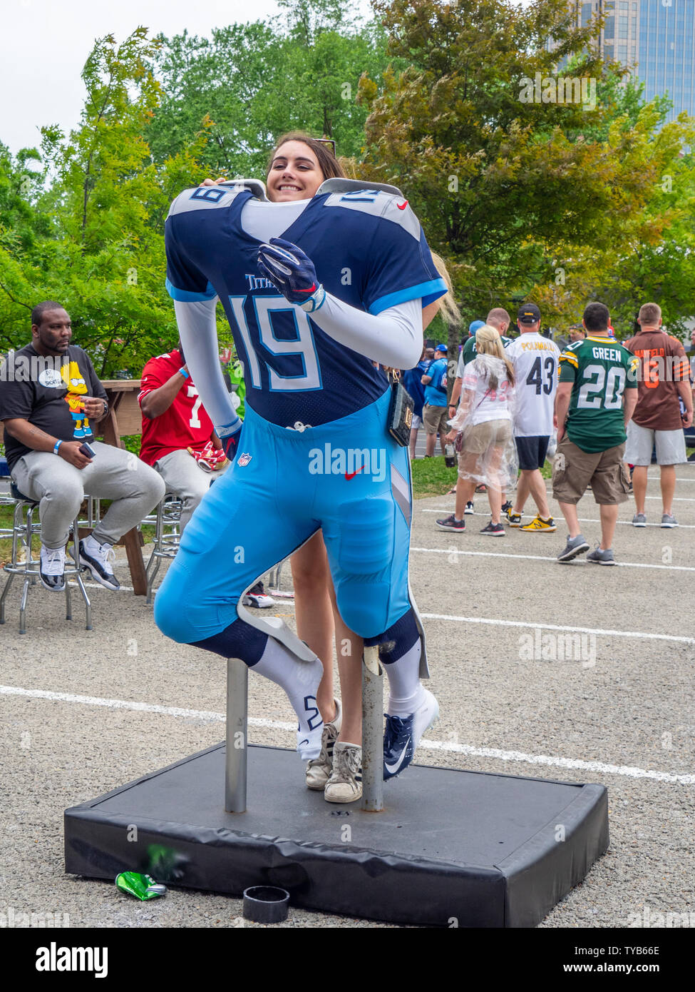 Female fan posing for a photograph standing behind a Tennessee Titans