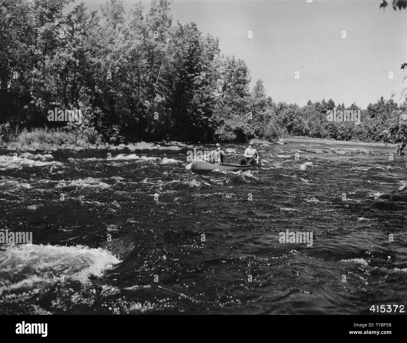 Photograph of Canoe Negotiating White Water on a Fishing Trip; Scope and content:  Original caption: Negotiating white water while on a fishing trip on the North Fork of Flambeau River. Stock Photo