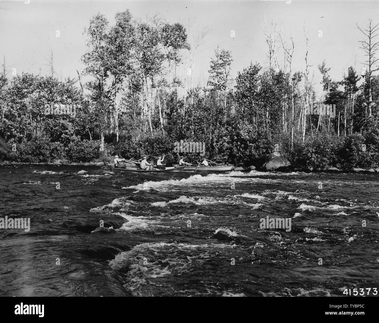 Photograph of Canoes Negotiating White Water on a Fishing Trip; Scope and content:  Original caption: Negotiating white water while on a fishing trip on the North Fork of Flambeau River. Stock Photo