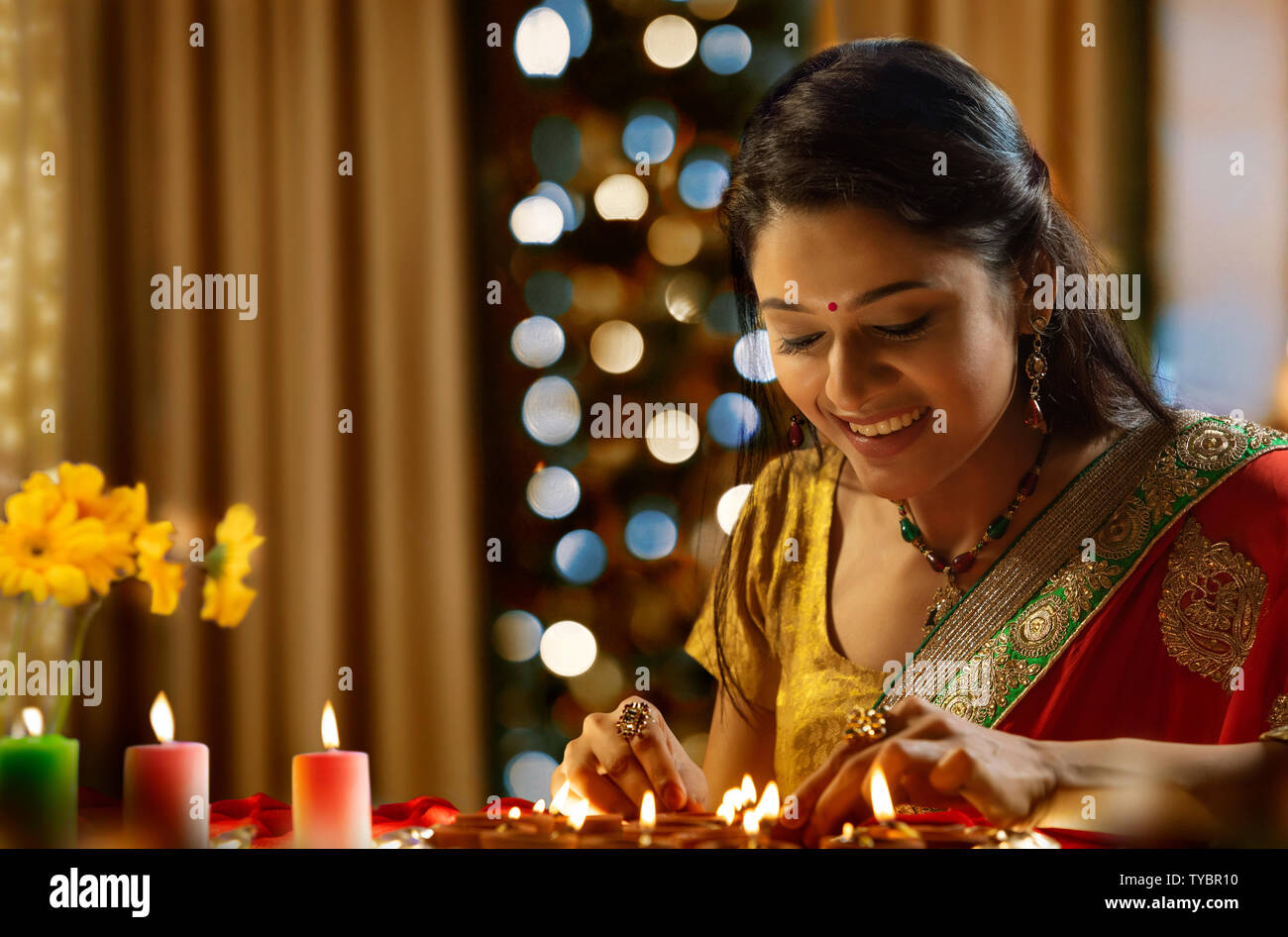 Woman decorating the house with diya on the occasion of diwali Stock Photo