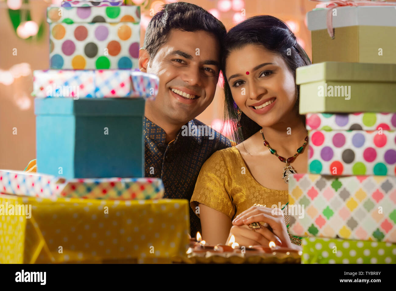 Husband and wife dressed up on the occasion of diwali with gifts on the table Stock Photo