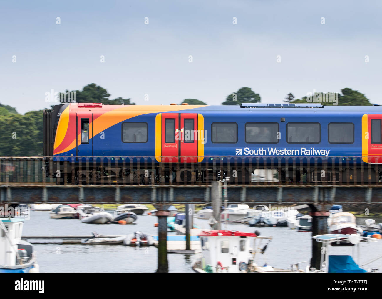 South Western Railway train crossing a bridge over the river in Lymington heading to the Lymington Ferry Stock Photo