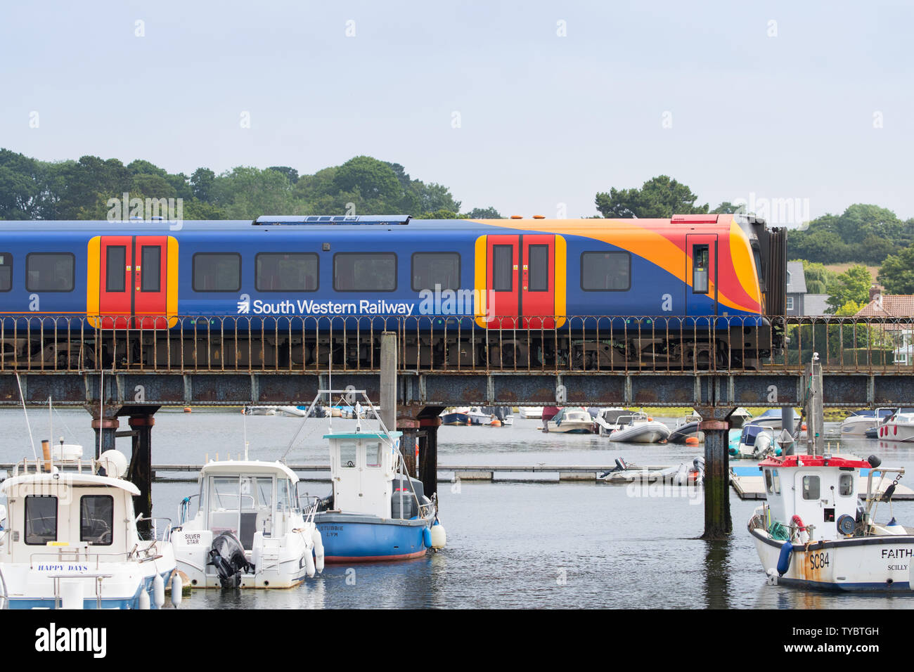 South Western Railway train crossing a bridge over the river in Lymington heading to the Lymington Ferry Stock Photo