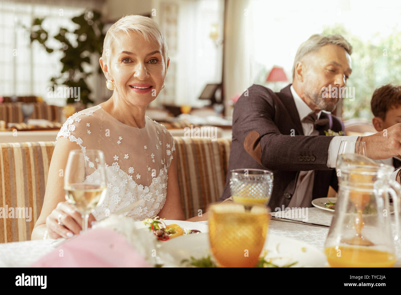 Aged couple feeling happy celebrating wedding with family Stock Photo