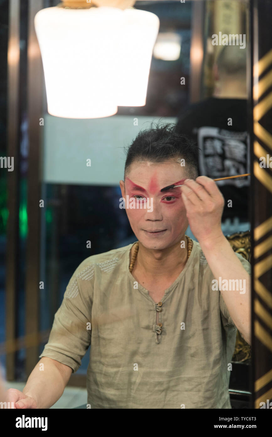 Traditional Chinese actor applies makeup before a performance in a Chinese theatre. Photographed in Chengdu, Sichuan, China Stock Photo