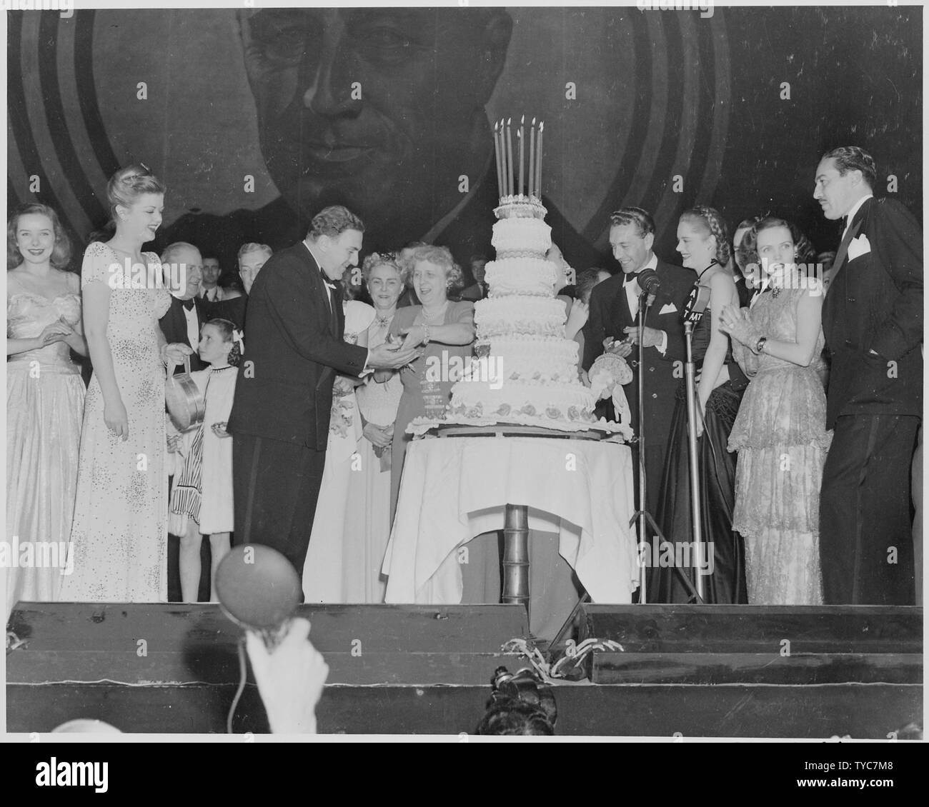 Photograph of First Lady Bess Truman giving a piece of birthday cake to