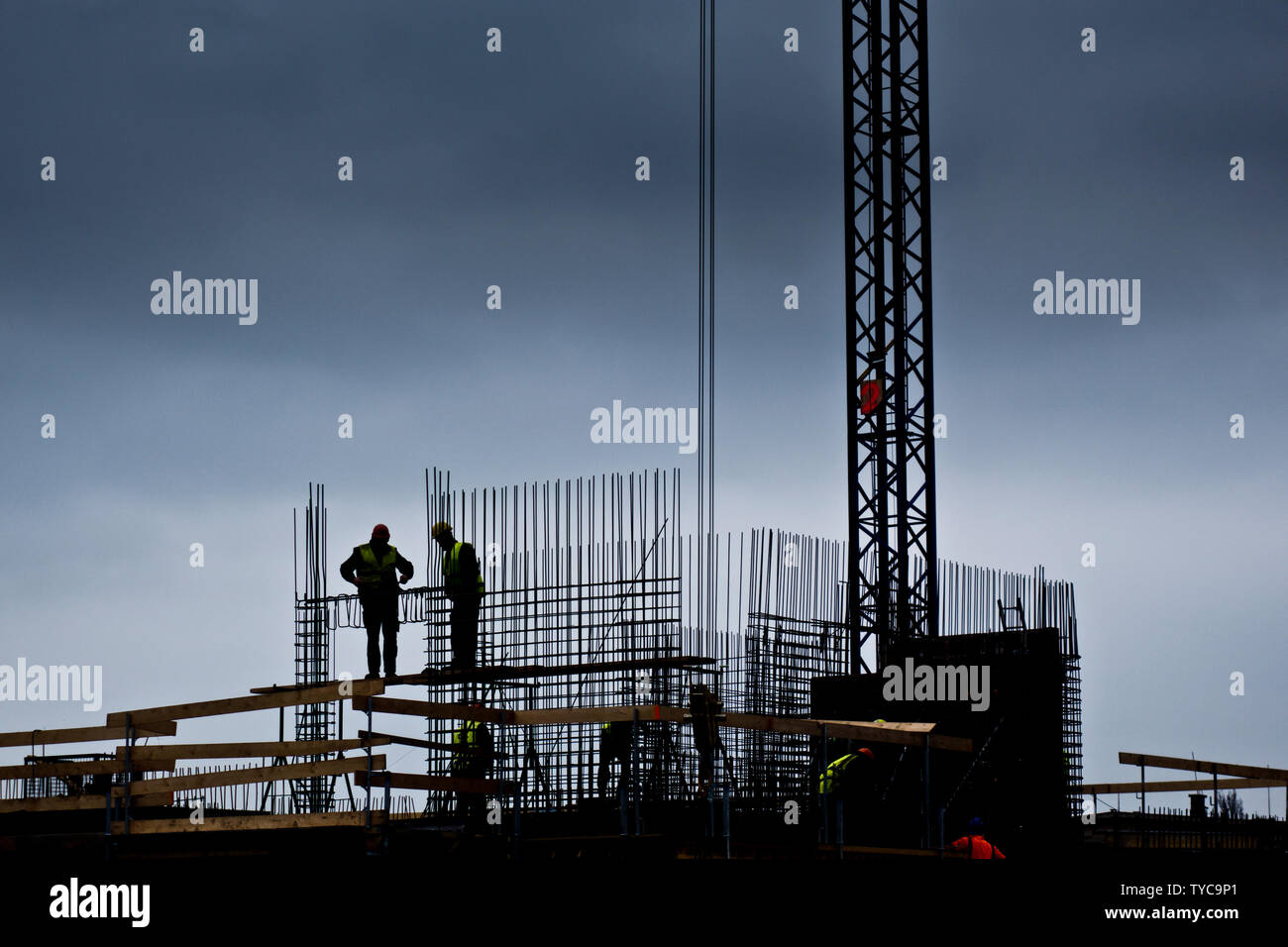 silhouette of two workers on the top of a building in construction Stock Photo