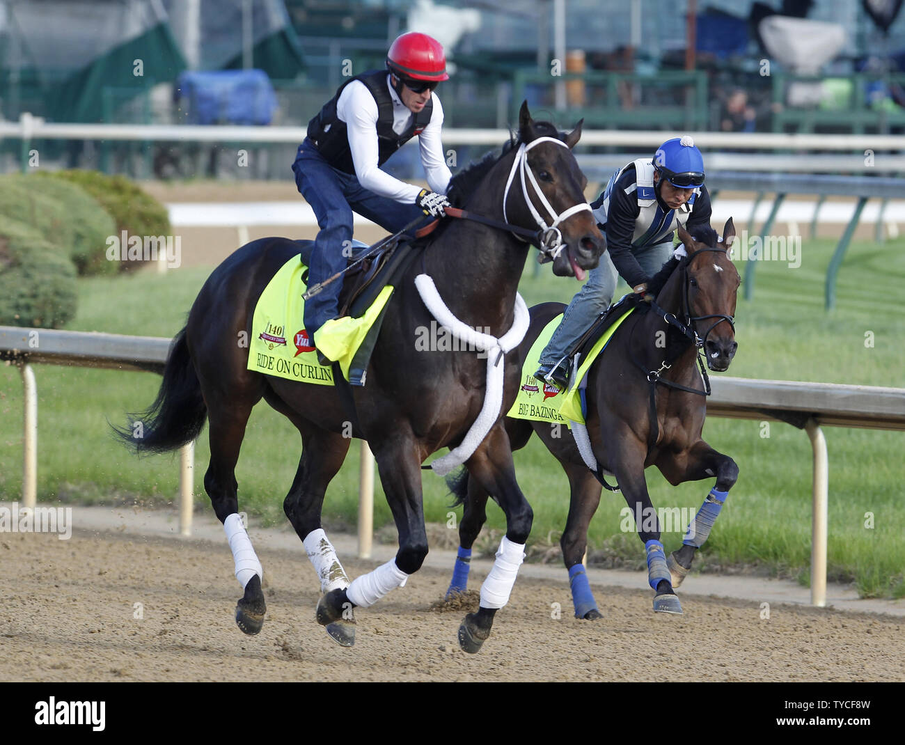 Exercise rider Bryan Beccia on Kentucky Derby entrant Ride On Curlin (L)  and Exercise rider Loren Diego takes Kentucky Derby hopeful Big Bazinga (R)  gallop on the track during morning workouts at, image size:1300x1070
