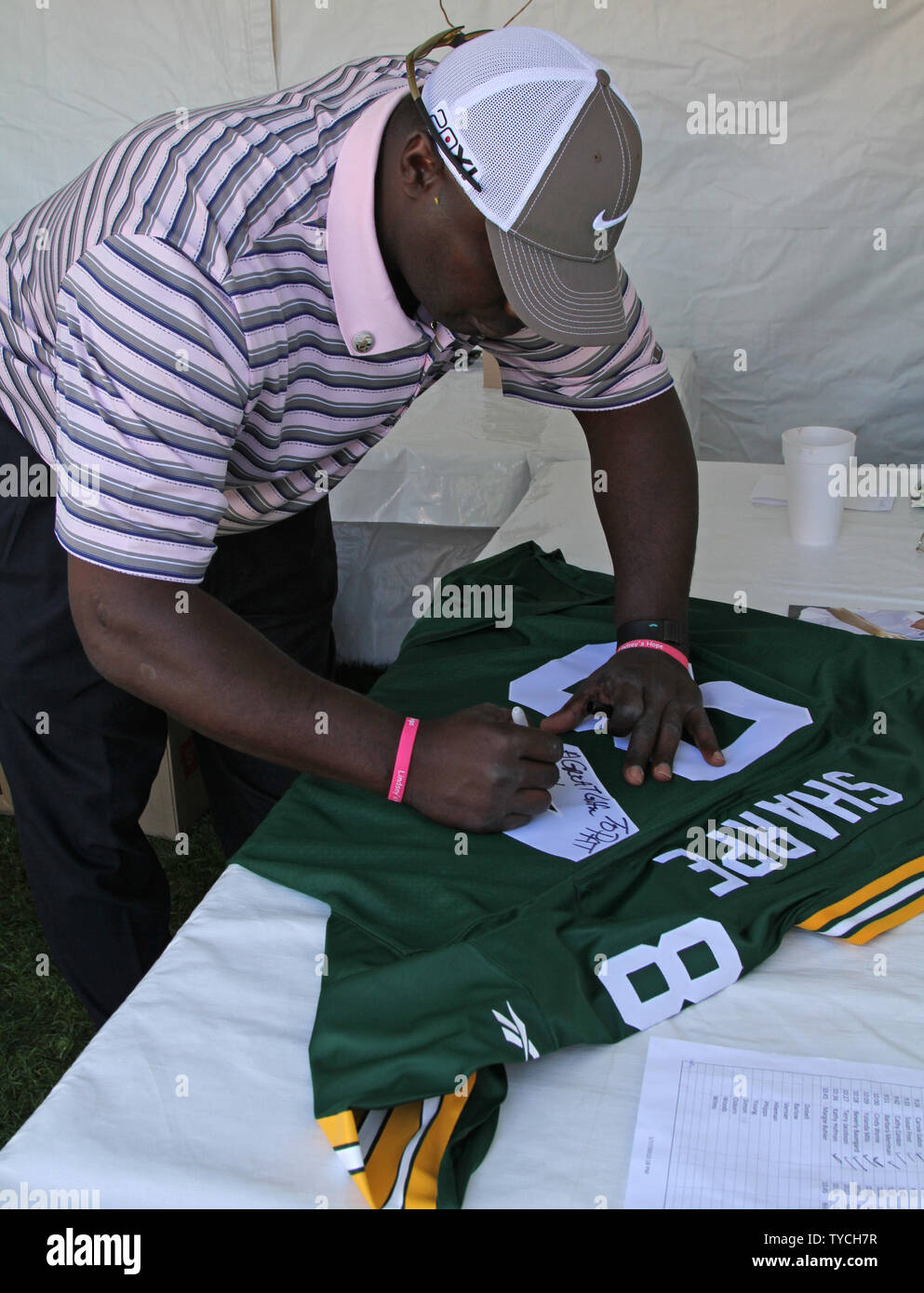 Former NFL player and current TV analyst Sterling Sharpe autographs a jersey during the Bob Hope Chrysler Classic at PGA West in La Quinta, California on January 22, 2011.  The tournament teams professional and amateur golfers with celebrities and has been raising money for a variety of charities since 1960.   UPI/ David Silpa Stock Photo
