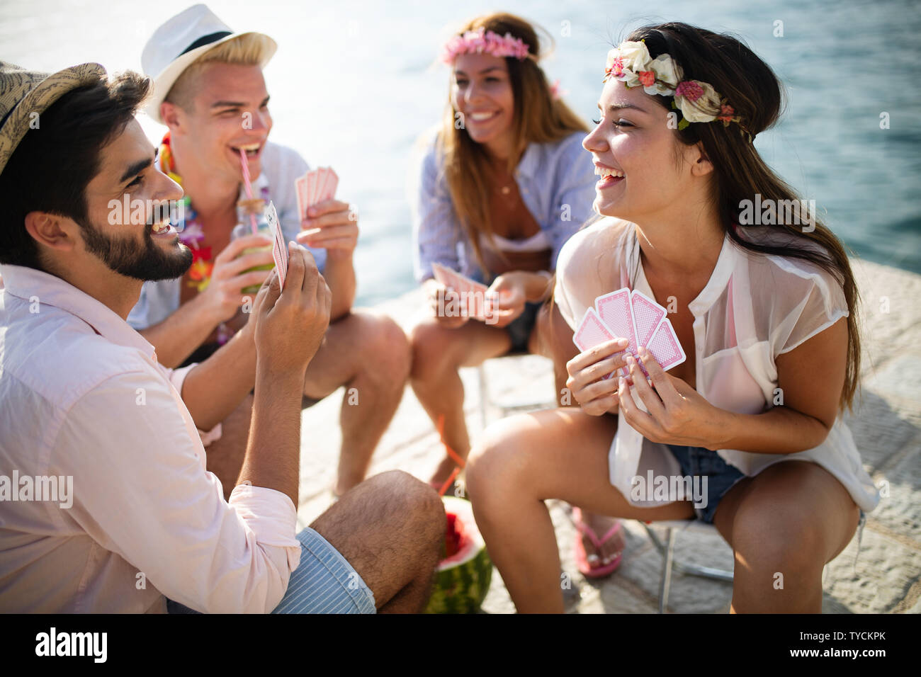 Group of happy friends playing carts and having fun Stock Photo
